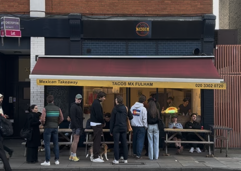 People standing outside a Mexican restaurant in London, England.